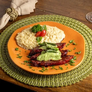 <p>Lombinho de porco na moita - Lombo suíno regado com molho de alcaparras, risoto de limão siciliano e chips de mandioca.</p>