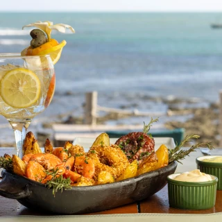 <p>Tábua de Frutos do Mar - Lula empanada, camarão e polvo grelhados com batatas rústicas fritas, um toque de alecrim e molho aioli.</p>
<p>Caju Tônica - Gin, sumo de limão, tônica e caju</p>