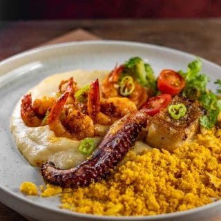 <p>Trio Nordestino - Camarão, Polvo e Filé de Pescada Amarela grelhados. Acompanha purê de mandioca, farofa crocante de castanha de caju, tapioca em flocos e azeite de pilão</p>