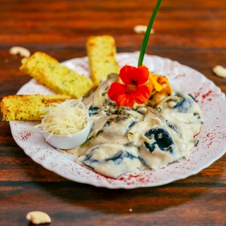<p>Ravióli de abóbora, gorgonzola e nozes com massa de cacau, e molho de castanhas de caju, umbu e capim-santo</p>