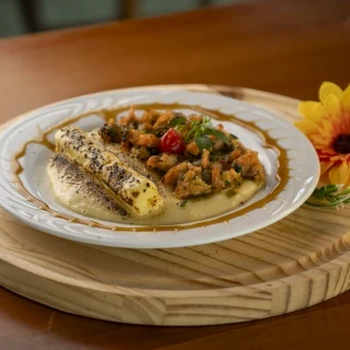 <p>Sol de Itaparica - Camarão coberto com fios de molho pesto e queijo coalho maçaricado, finalizado com melaço de cana. Acompanha pirão de aipim.</p>