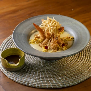 <p>Raízes do Mangue - Camarão empanado com musseline de mandioca manteiga, farofa de cuscuz, fonduta de provolone, batata palha artesanal e melaço de umbu</p>