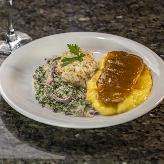 <p>Salmão com geleia de mangaba levemente picante. Acompanha aligot de mandioca, arroz no coco e farofa de couve com cebola roxa</p>