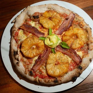 <p>Havaiana Rebelde. Pizza com massa de cacau 100%, bacon e abacaxi grelhado.</p>