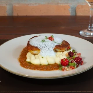 Mata & Maré - Pescada Amarela, envolvida em crosta de acarajé dourada, crocante e frita no dendê. Acompanha purê de inhame, vinagrete de pimenta-de-cheiro e pitanga, molho de aratu e espuma de leite de coco com gengibre