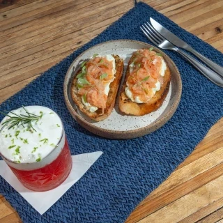Drink e Aperitivo - Pepita da Chapada - Equilíbrio perfeito entre o frescor da pitanga, o cítrico do limão e as notas herbais da espuma de manjericão. Acompanha bruschettas, com pães artesanais de lenta fermentação, e salmão defumado na Casa, com creme de ervas frescas da cozinha da Nutrir