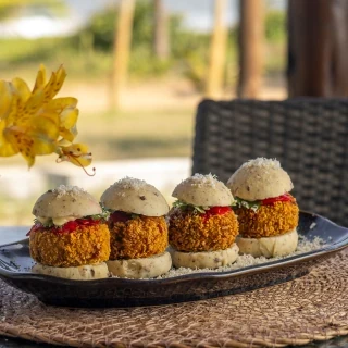 <p>Mini hamb&uacute;rguer de Siri, empanado e frito no dend&ecirc;, feito no p&atilde;ozinho del&iacute;cia de licuri, com aioli de pimenta de cheiro, picles de cebola e coentro</p>